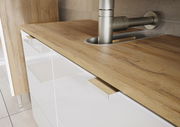 Nahaufnahme eines Unterschranks mit Holzarbeitsplatte und Edelstahlarmatur, seitliche Perspektive
