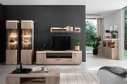 Moderne Wohnzimmermöbelkombination mit LED-Beleuchtung, bestehend aus Highboards, Sideboard und Wandregal in Holzoptik, frontal betrachtet.
