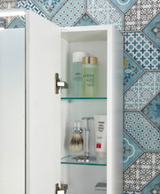 Geöffneter Spiegelschrank mit zwei Glasböden, gefüllt mit Pflegeprodukten und Rasierzubehör, vor einer dekorativen blauen Fliesenwand. Perspektive von vorne.