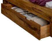 Holz-Schubkasten unter einem Bett, teilweise geöffnet, mit Bettwäsche gefüllt, seitliche Perspektive