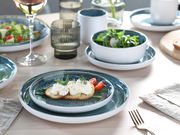 Kombiservice 16-tlg. Eisblau, bestehend aus Tellern und Schalen in einem eleganten Design, auf einem gedeckten Tisch von oben fotografiert.