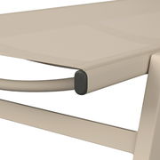 Nahaufnahme einer Sonnenliege aus beigem Material mit abgerundeten Kanten, seitliche Perspektive