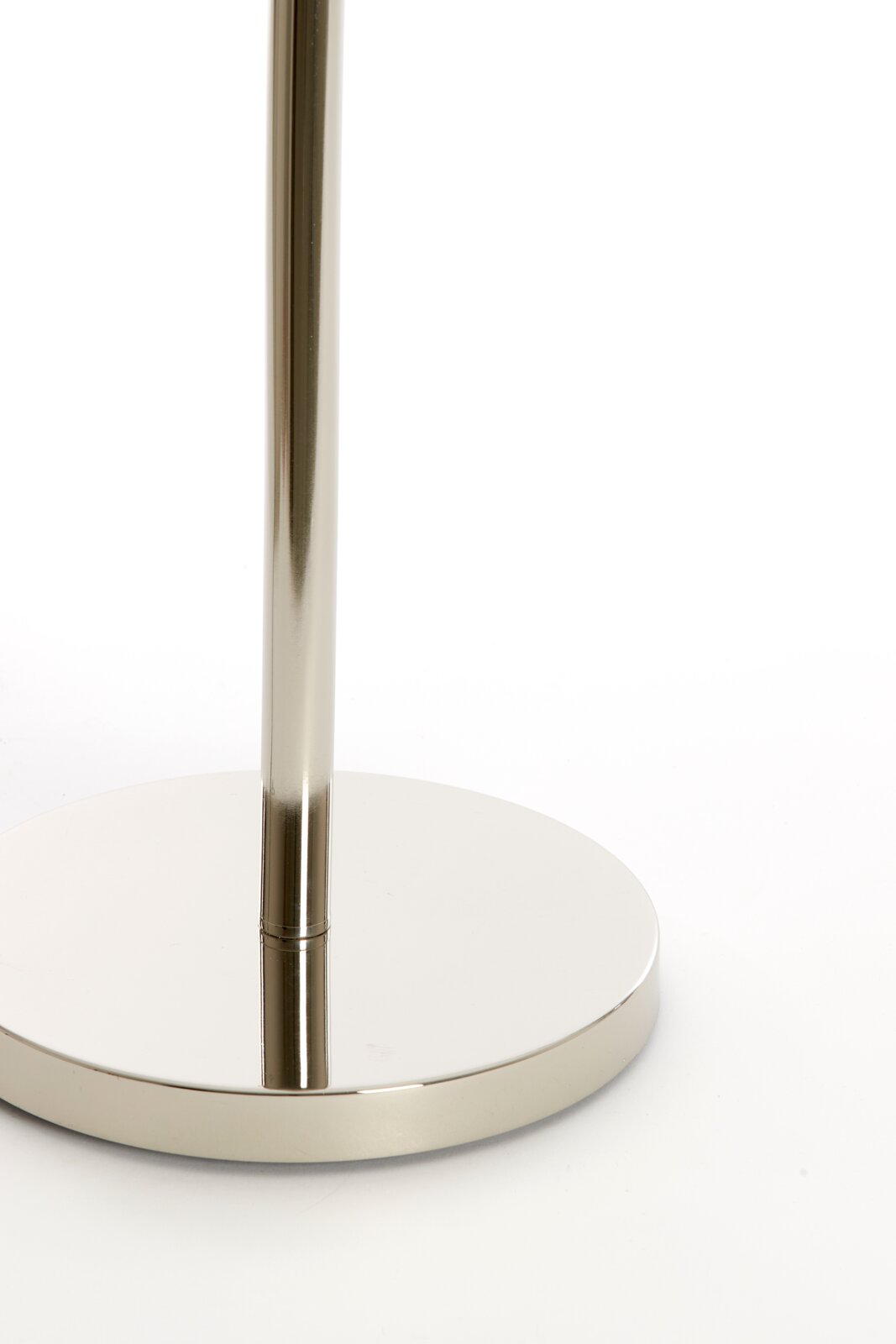 Close-up van de voet van een moderne staande lamp van glanzend metaal.