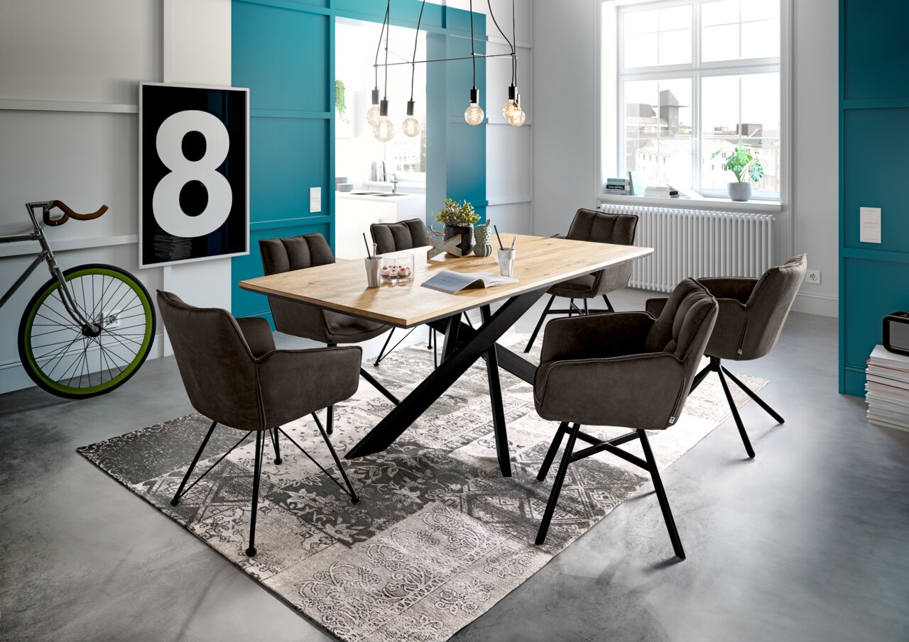 Esszimmer mit modernem Holztisch und sechs drehbaren Armlehnstühlen der Serie FRISCO von Set One by Musterring, seitliche Perspektive.