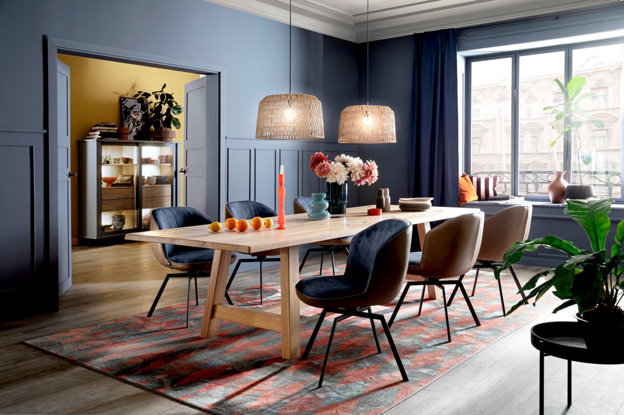 Moderne houten eettafel in een stijlvol ingerichte eetkamer, zijaanzicht