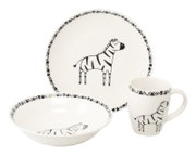 Weißes Kindergeschirr-Set mit schwarzen Zebra-Motiven, bestehend aus Teller, Schale und Henkelbecher, in schräger Vorderansicht