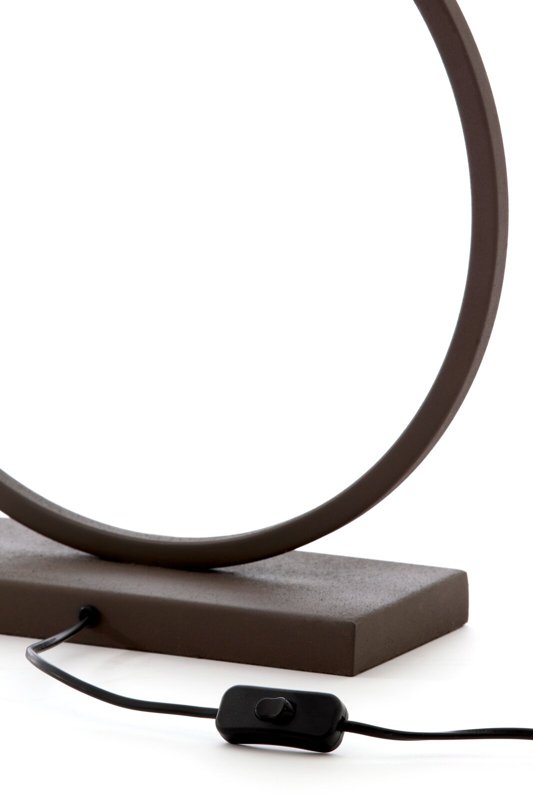 Detailaufnahme einer modernen Tischleuchte mit ringförmigem Rahmen in Dunkelbraun auf rechteckigem Sockel, mit schwarzem Kabel und Inline-Schalter, seitliche Perspektive