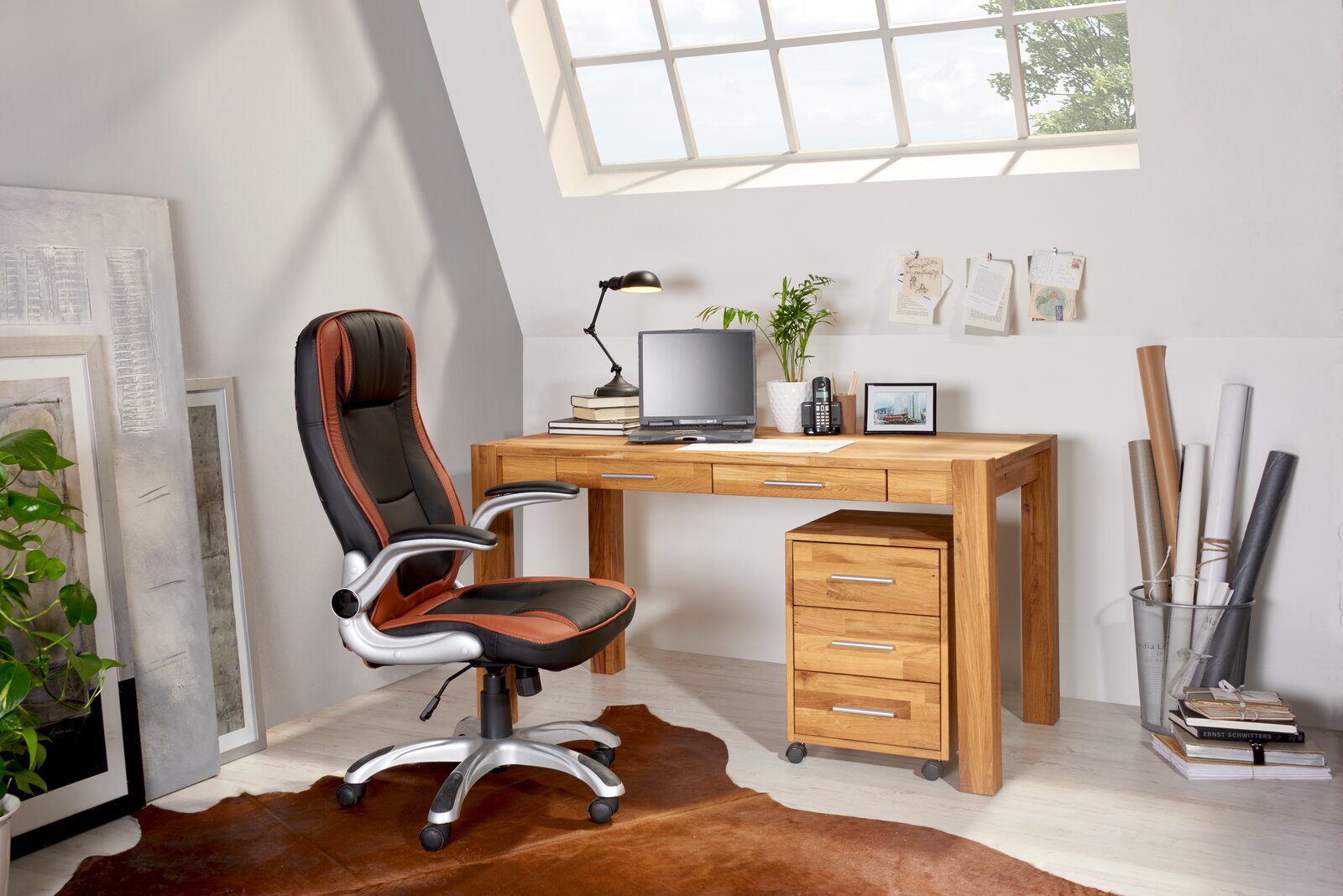 Moderner Schreibtisch aus Holz mit drei Schubladen, Laptop und Büromaterialien, seitliche Perspektive