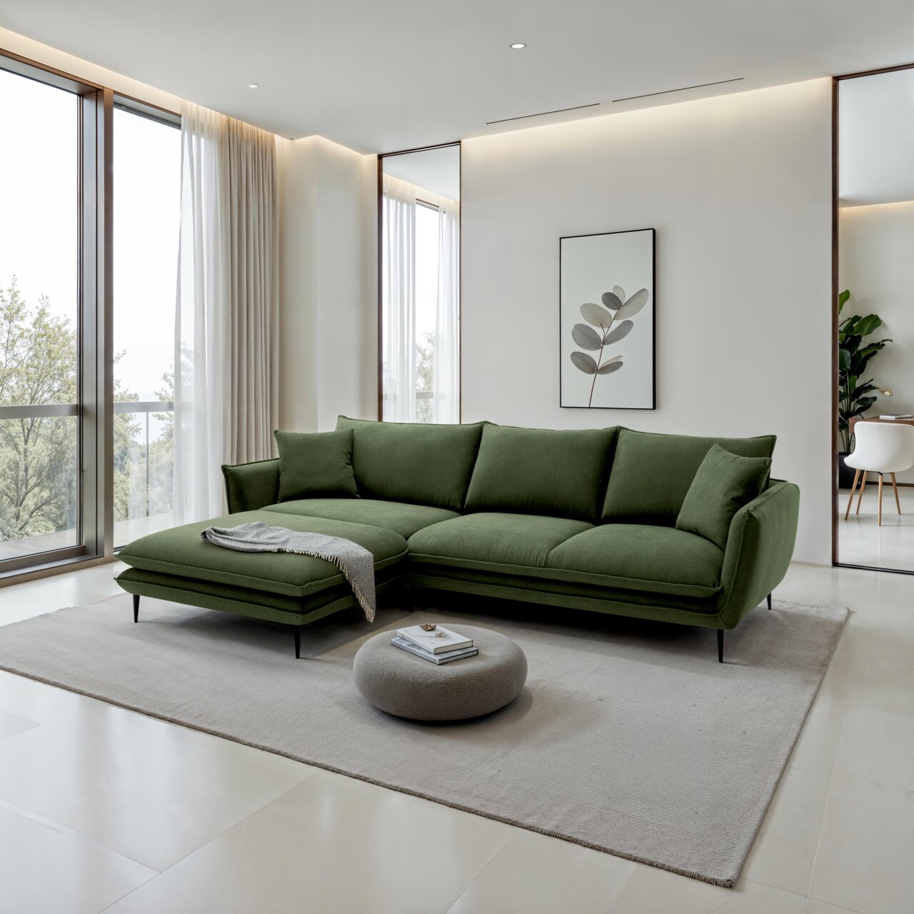 Grünes modernes Ecksofa mit Recamiere links und schwarzen Metallfüßen in hellem Wohnzimmer auf Teppich, fotografiert in frontaler leicht schräger Perspektive von vorn.