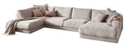 Beige Polsterrundecke in L-Form mit mehreren Kissen und einer Decke, seitliche Perspektive