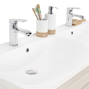 Moderner Waschplatz mit zwei Wasserhähnen, Seifenspender und Zahnbürstenhalter, aus der Vogelperspektive fotografiert.