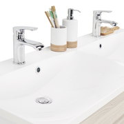 Moderner Waschplatz mit zwei Wasserhähnen, Seifenspender und Zahnbürstenhalter, aus der Vogelperspektive fotografiert.