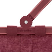 Close-up van een rode draagmand met het logo 'reisenthel' op de voorkant.