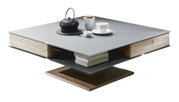 Moderner Couchtisch mit quadratischer grauer Tischplatte, Holzdetails und integriertem Stauraum, seitliche Perspektive.