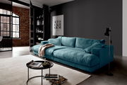 Großes, türkisfarbenes Megasofa in modernem Wohnzimmer, seitliche Perspektive