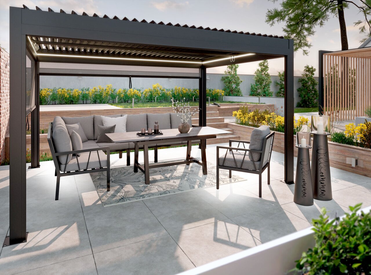 Amatio Pro Tuinstoel ZAMORA Moderne, antracietkleurige pergola met lamellendak en ingebouwde ledverlichting boven een buitenlounge met grijze gestoffeerde meubels en een eettafel op een terras, gefotografeerd vanuit een licht zijaanzicht vanaf de voorkant