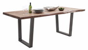 Moderne houten eettafel met metalen poten, gezien vanaf de zijkant, gedecoreerd met serviesgoed, glazen en een fles wijn.