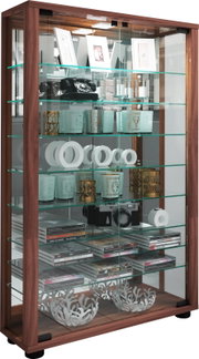 Holz-Vitrine mit Glasfront und mehreren Glasböden, dekoriert mit Bilderrahmen, Kerzenhaltern, Vintage-Telefon, Kamera und CDs, schräg von vorn aufgenommen
