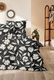 Bettwäsche-Set mit floralem Muster in Schwarz-Weiß, fotografiert aus einer seitlichen Perspektive im Schlafzimmer.