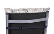Achterkant van een stoelbekleding met tropisch bladmotief, bevestigd aan een metalen stoel.