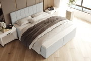 Hellgraues Boxspringbett mit gepolstertem, kariert abgestepptem Kopfteil und weiß-grauer Bettwäsche im modernen Schlafzimmer, schräg von oben aus der Ecke fotografiert