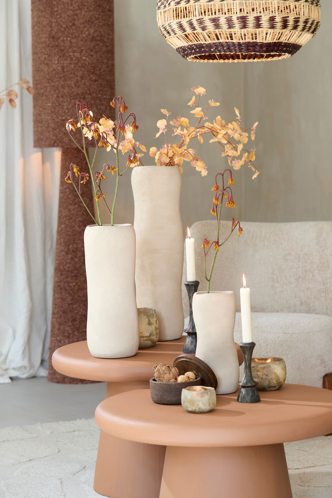 Light&Living Vase SERAFINA 28cm Drei elegante, cremefarbene Vasen mit Blumenarrangements auf einem runden, terrakottafarbenen Tisch, seitliche Perspektive.