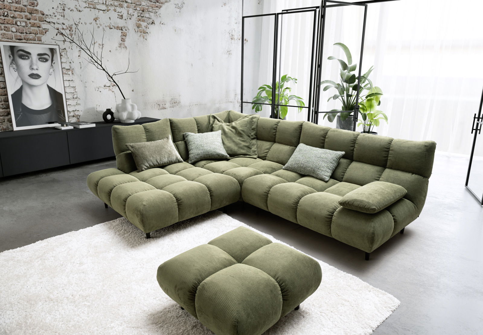 Grüne Eckgarnitur in modernem Wohnzimmer mit industriellem Design, fotografiert aus einer leicht erhöhten Perspektive.