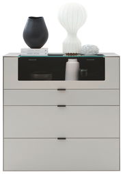 Frontansicht eines modernen Highboards mit drei Schubladen, dekoriert mit einer schwarzen Vase, einer weißen Lampe und Büchern.