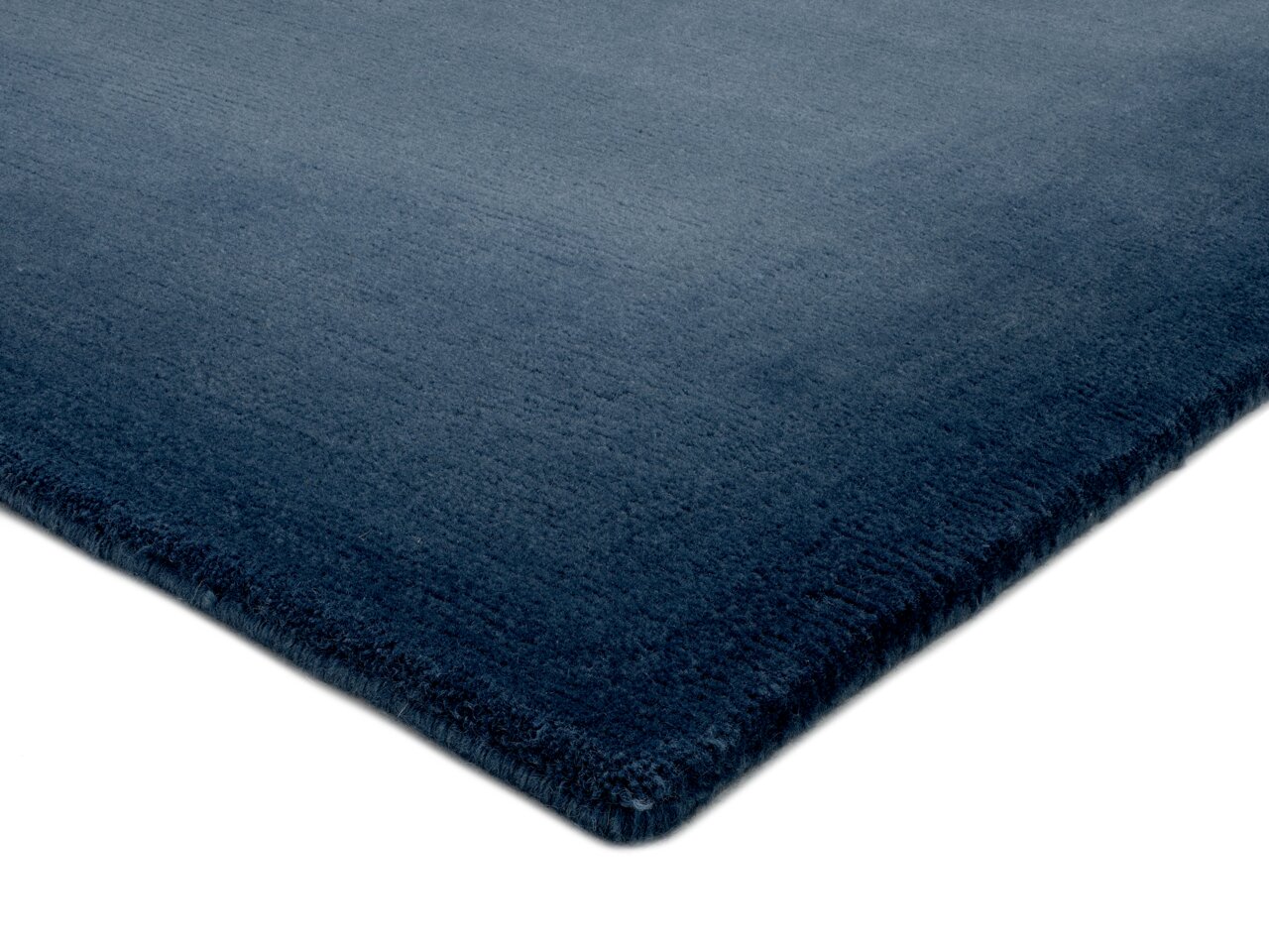 Ecke eines blauen Teppichs, perspektivisch von der Seite aufgenommen