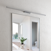 Moderne LED-Wandleuchte über einem Spiegel, seitliche Perspektive