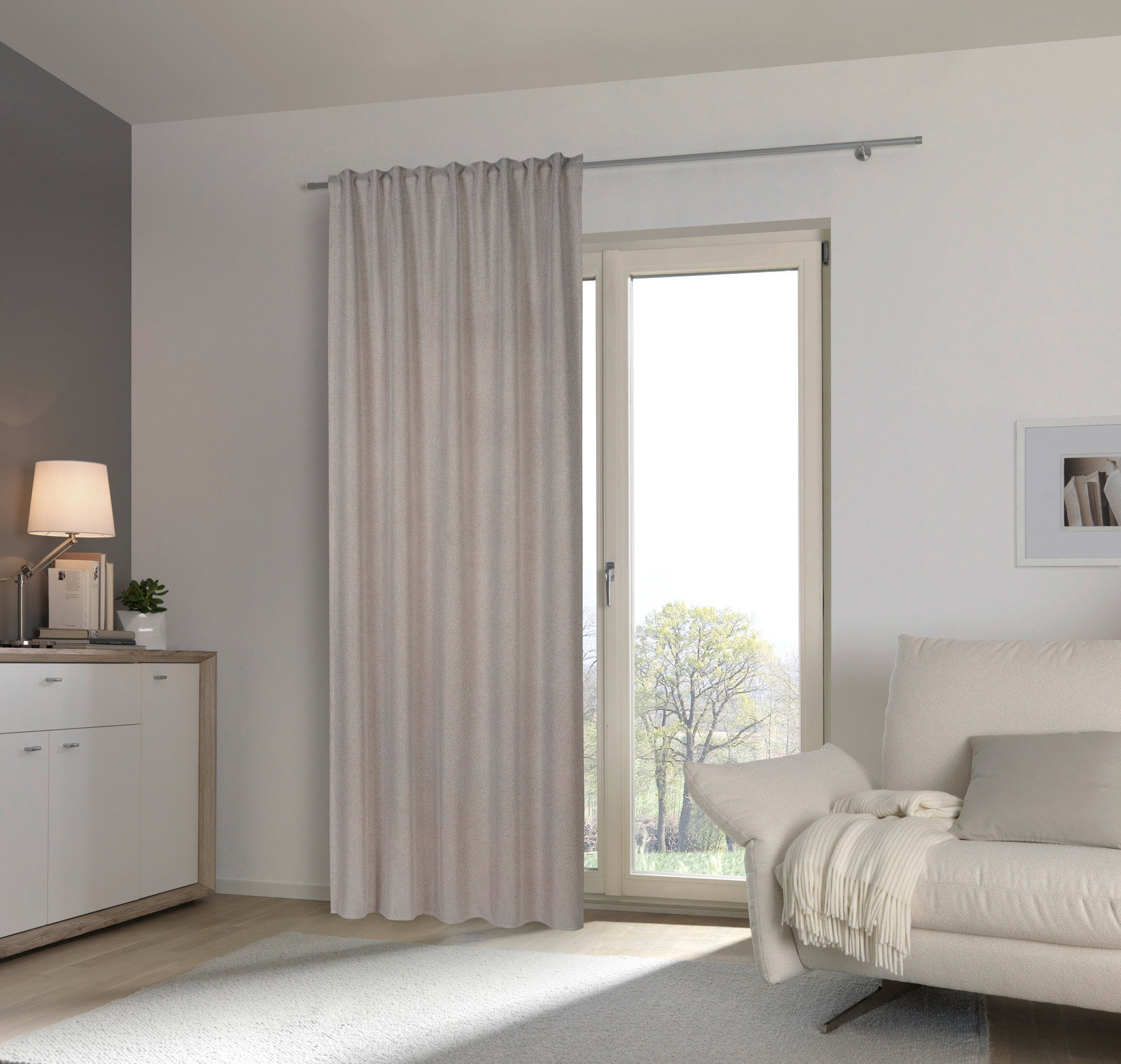 Fertigvorhang in einem modernen Wohnzimmer, aufgehängt an einer Gardinenstange vor einer Glastür, mit Blick auf einen hellen, gemütlichen Raum.