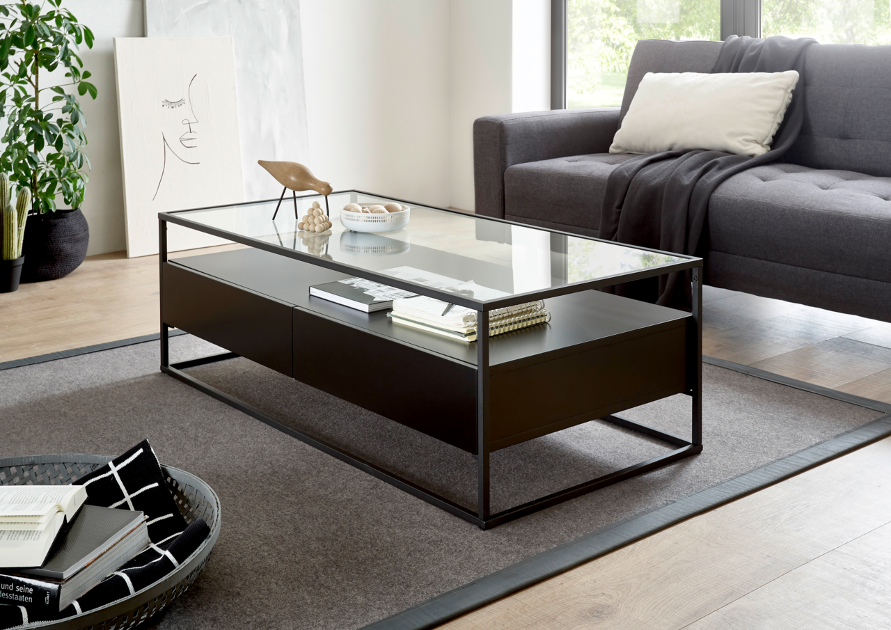 Moderner Couchtisch mit Glasplatte und schwarzem Metallrahmen, seitliche Perspektive