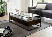 Moderner Couchtisch mit Glasplatte und schwarzem Metallrahmen, seitliche Perspektive