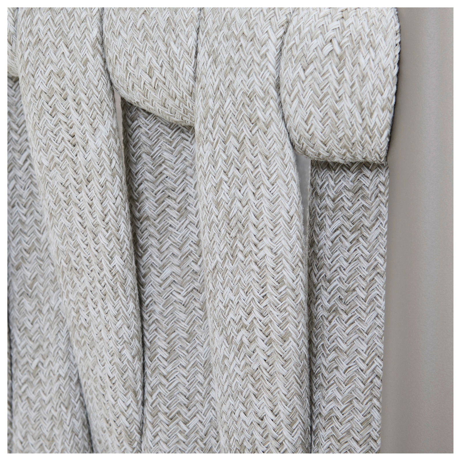 Nahaufnahme eines Gartensessels mit geflochtenem Seilgewebe in Beige, seitliche Perspektive