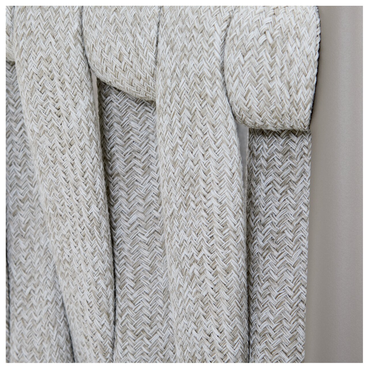 Nahaufnahme eines Gartensessels mit geflochtenem Seilgewebe in Beige, seitliche Perspektive