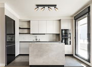 Moderne Küche mit einem an der Decke montierten Strahler mit vier verstellbaren Leuchten, Blick von vorne.