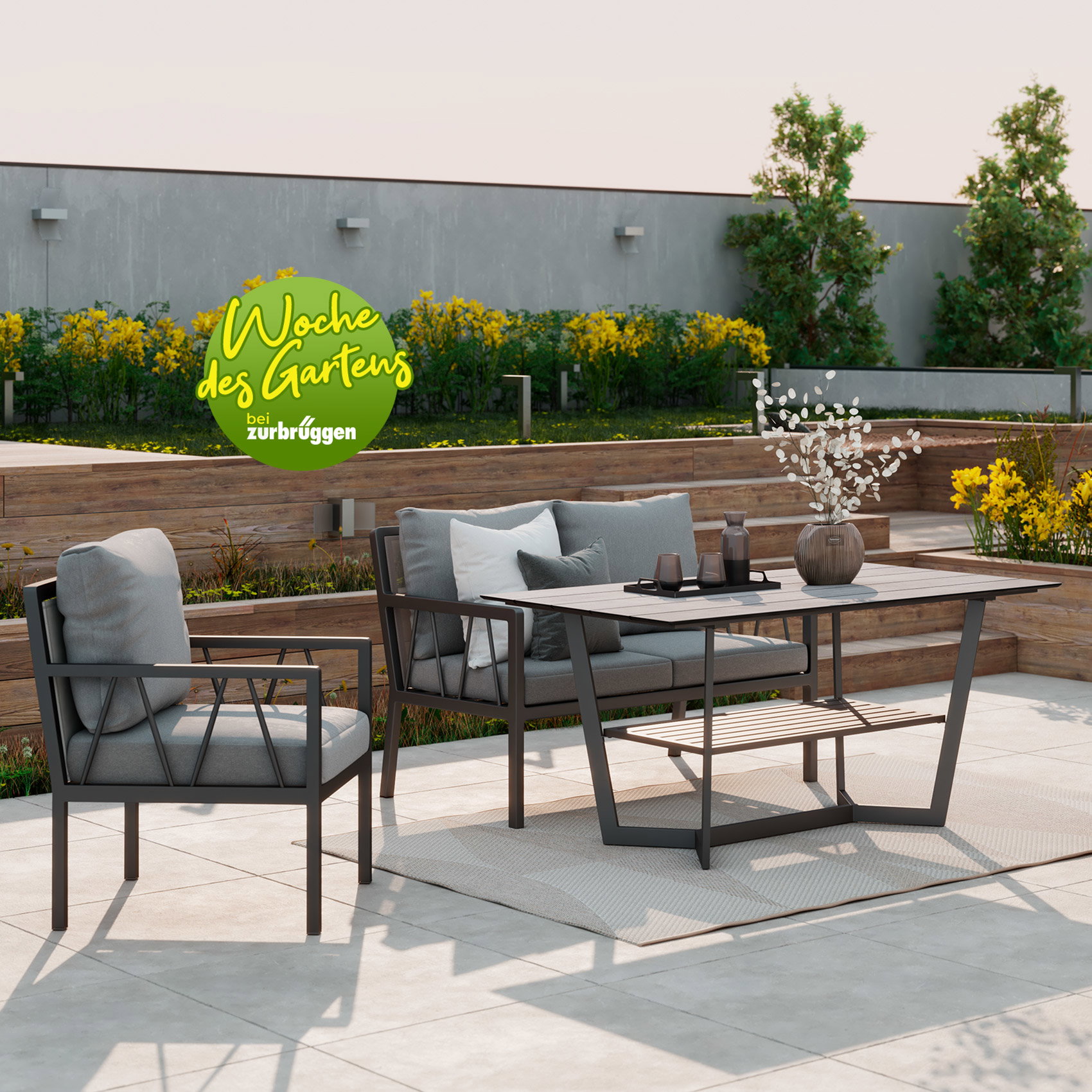 Moderne Outdoor-Lounge mit grauen Polstermöbeln und rechteckigem Gartentisch auf heller Terrasse vor stilvoll angelegtem Garten mit Holzstufen und Pflanzen.