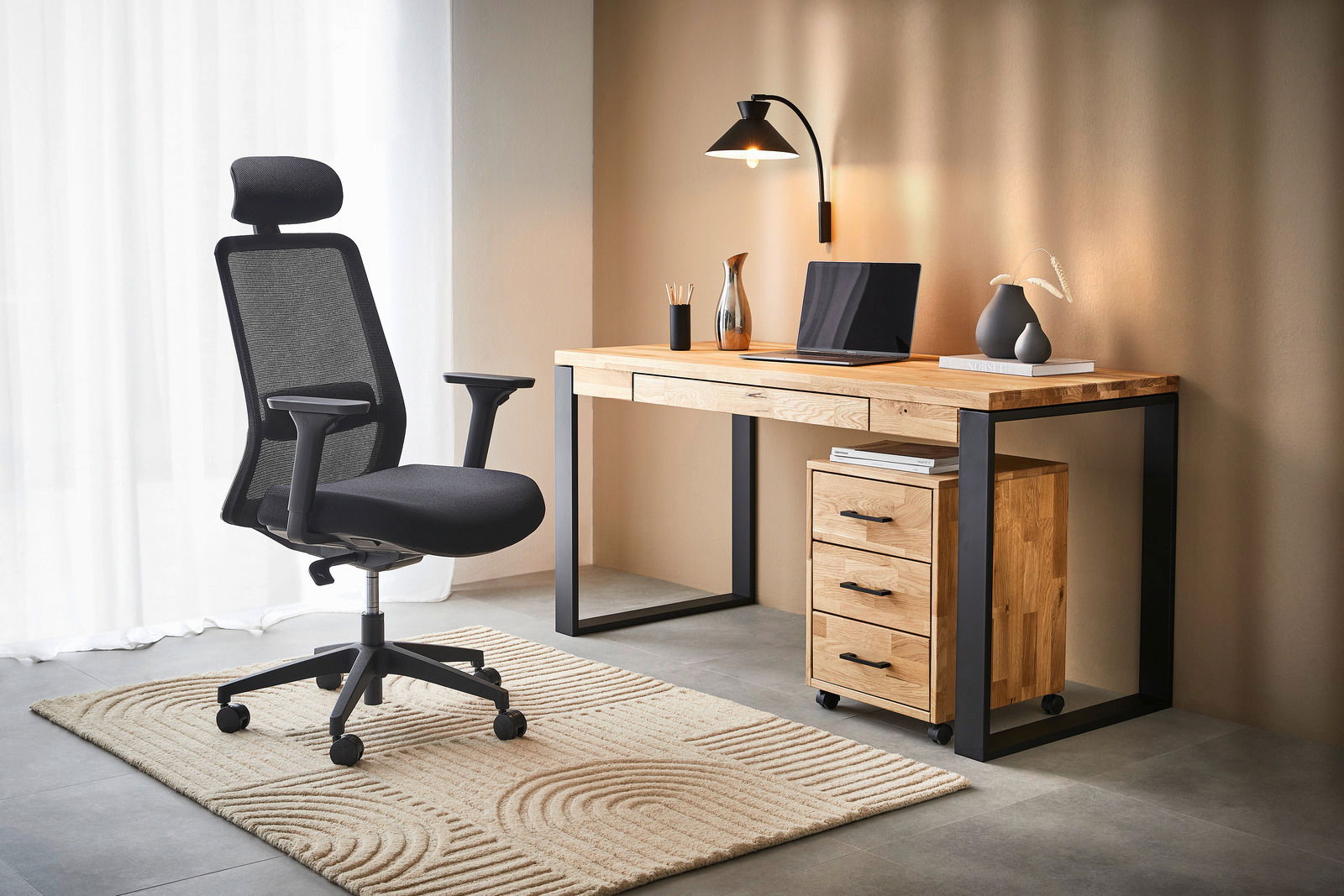 Moderner Rollcontainer aus Holz mit drei Schubladen, neben einem Schreibtisch in einem stilvollen Büro, seitliche Perspektive.