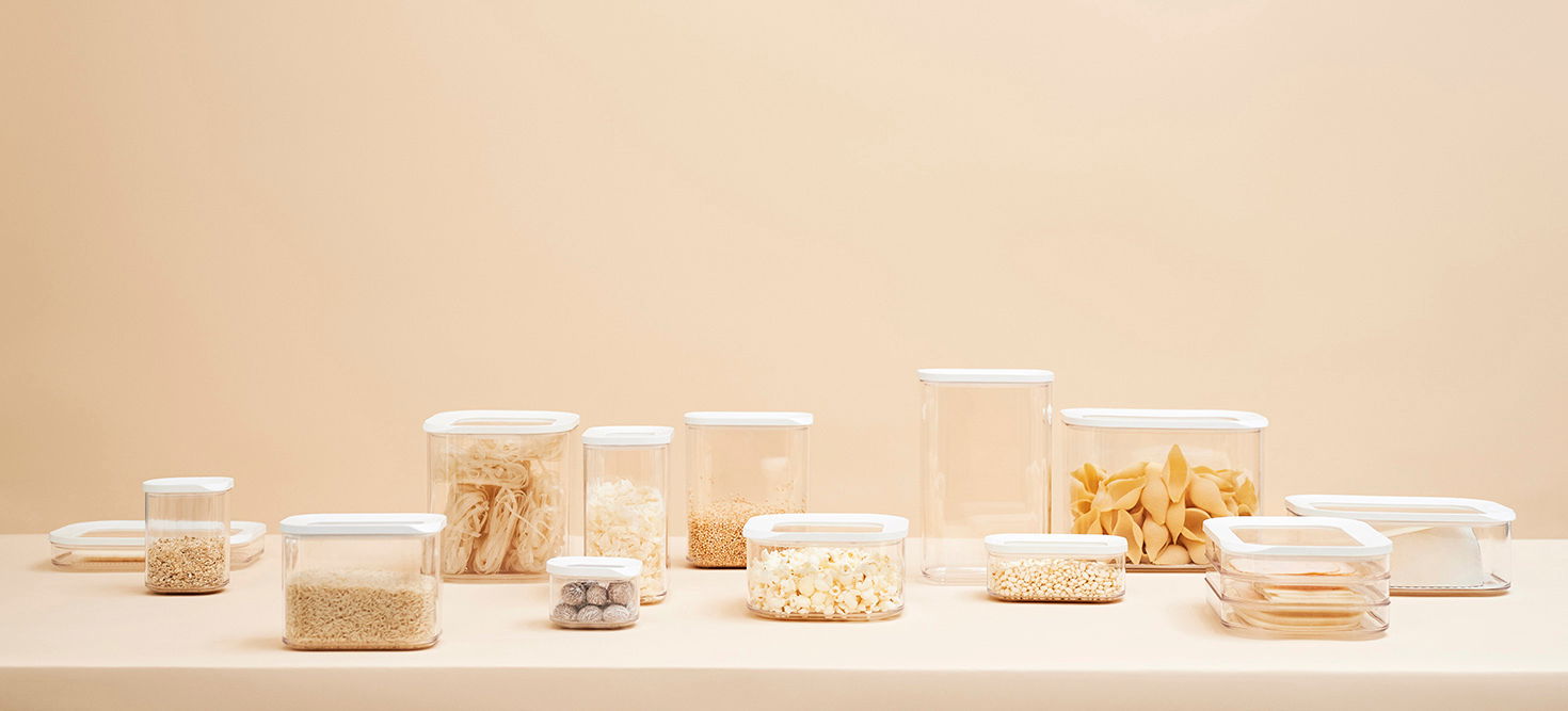Vorratsdosen Modula 1000 ml in verschiedenen Größen und Formen, gefüllt mit Lebensmitteln, auf einer neutralen Oberfläche aus seitlicher Perspektive.