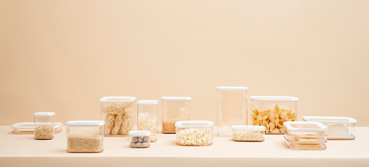 Vorratsdosen Modula 1000 ml in verschiedenen Größen und Formen, gefüllt mit Lebensmitteln, auf einer neutralen Oberfläche aus seitlicher Perspektive.