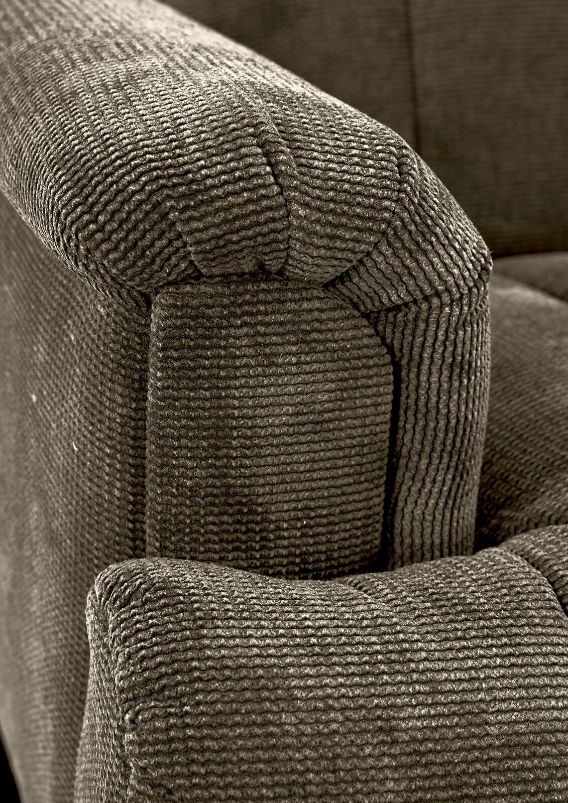 Nahaufnahme einer 2,5er-Sitzbank mit strukturiertem Stoffbezug, seitliche Perspektive auf die Armlehne.