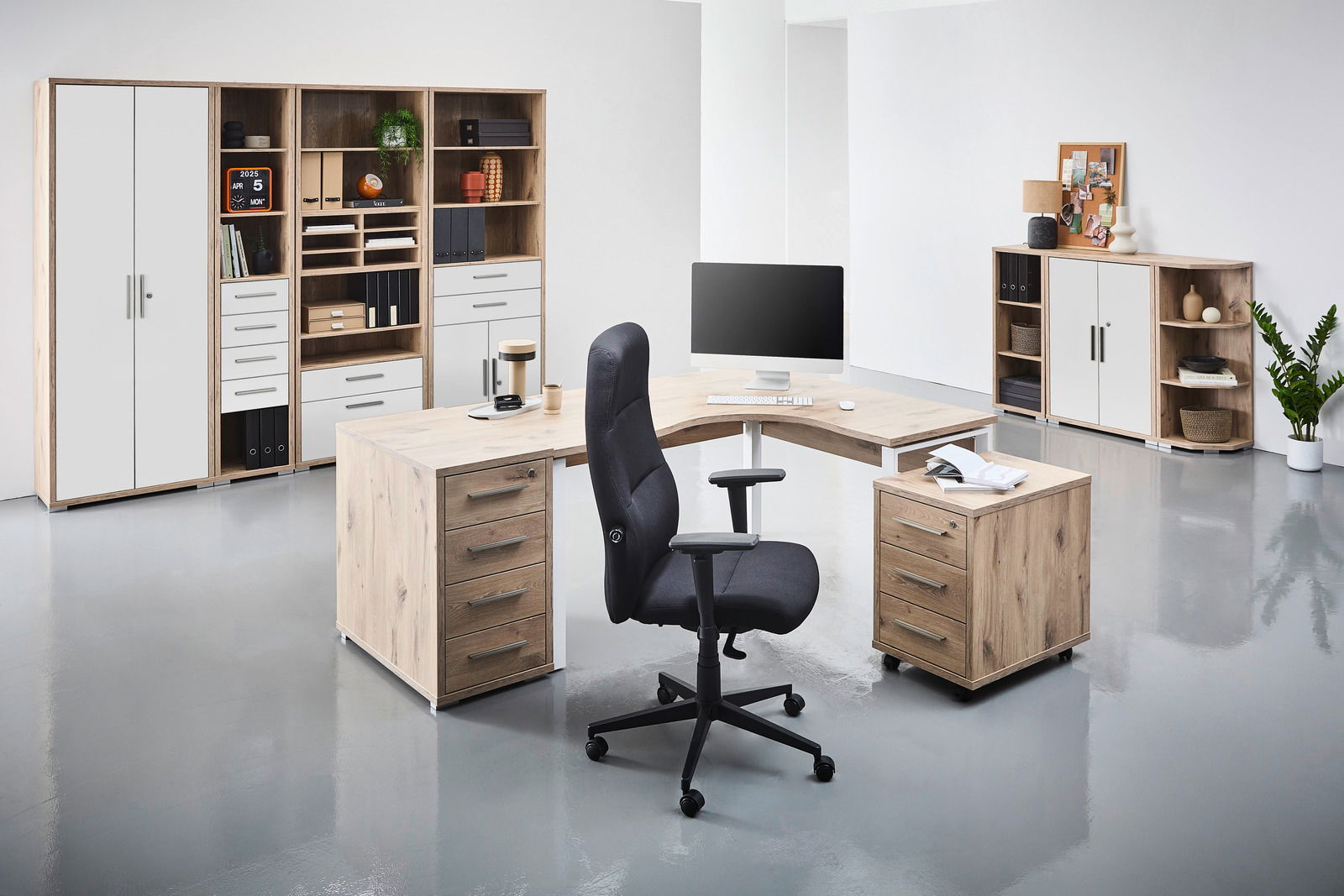 Moderne Büroumgebung mit einem Eckschreibtisch in Holzoptik, umgeben von Regalen und Schränken. Perspektive von vorne.