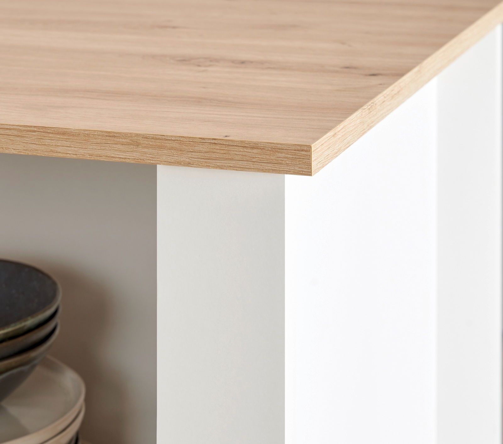 Detailansicht einer Kücheninsel mit Holzarbeitsplatte und weißen Seiten, Perspektive von der Ecke.