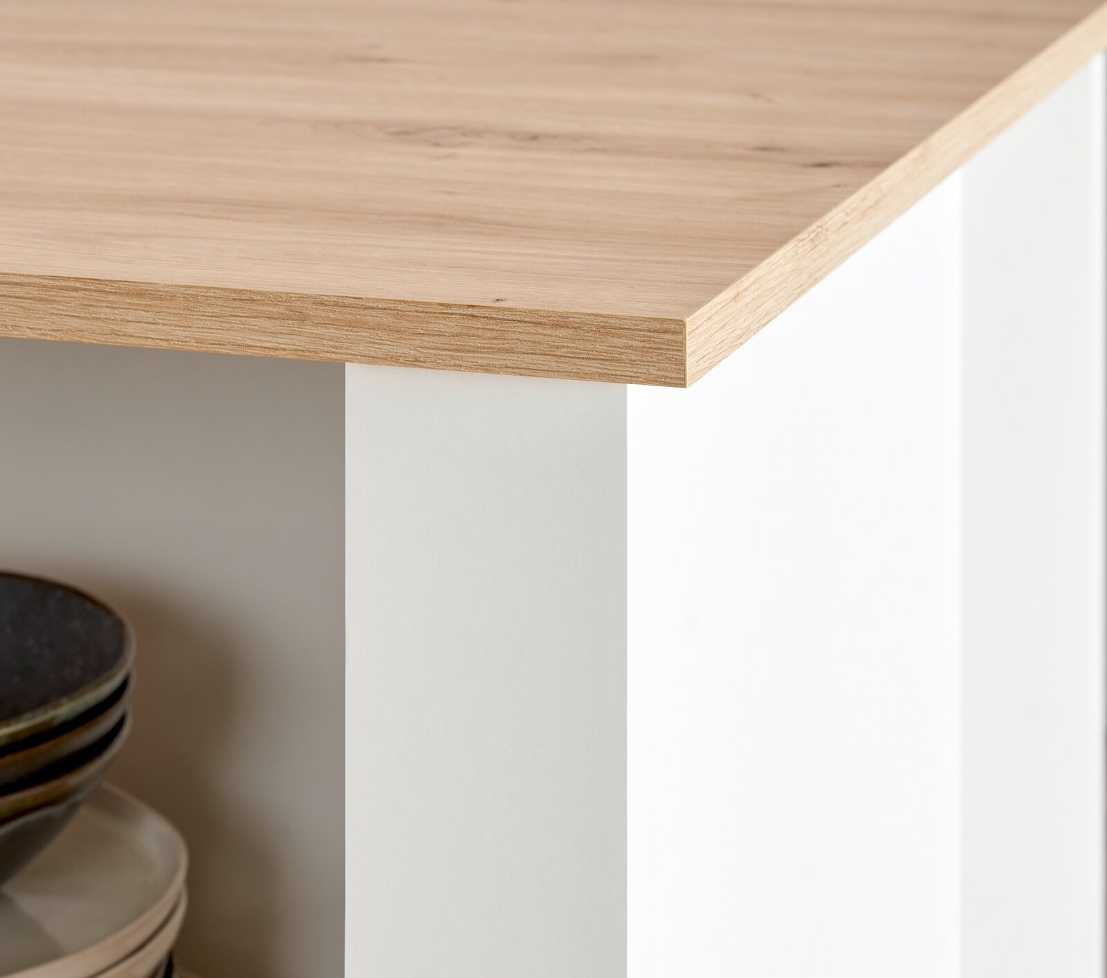 Detailansicht einer Kücheninsel mit Holzarbeitsplatte und weißen Seiten, Perspektive von der Ecke.