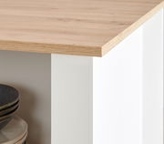 Detailansicht einer Kücheninsel mit Holzarbeitsplatte und weißen Seiten, Perspektive von der Ecke.