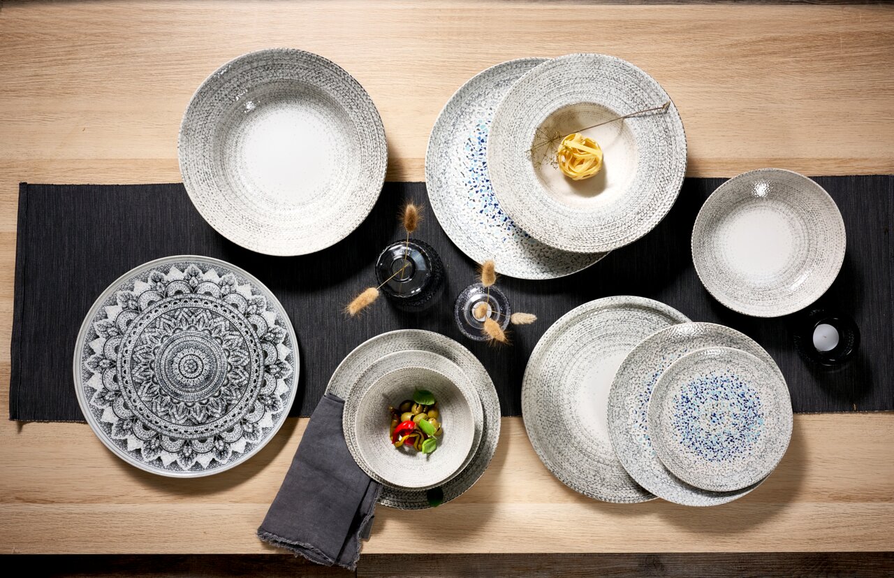 Ritzenhoff & Breker Pastateller RIMINI Verschiedene Pastateller in einem eleganten Design, von oben fotografiert, auf einem Holztisch mit dunkler Tischdecke arrangiert.