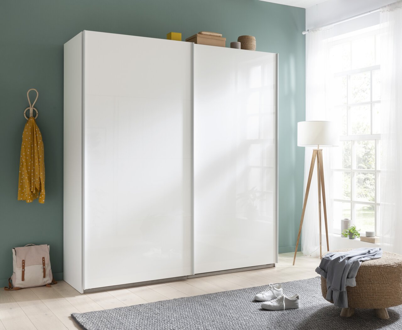 XORA Kast met zweefdeuren SYSTEMA Moderne witte hangkast in een lichte ruimte met houten vloer, zijaanzicht.