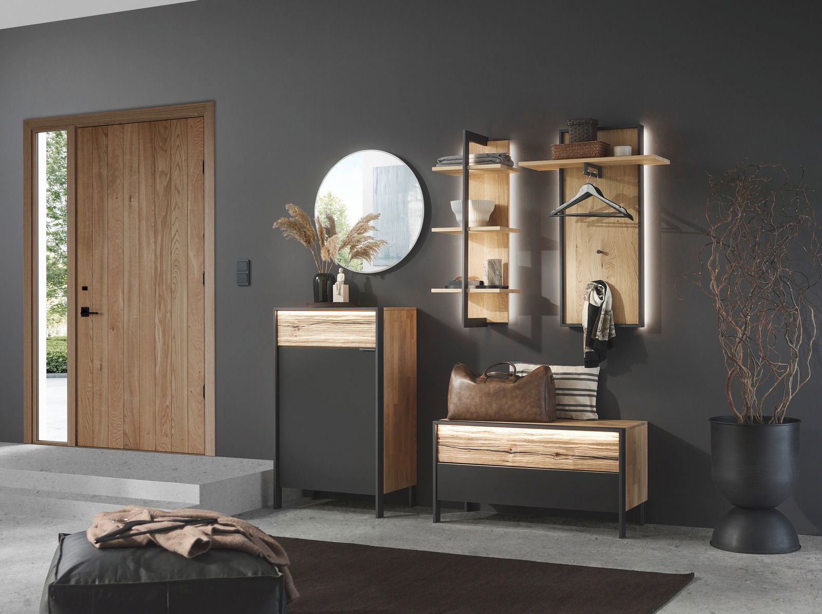 Moderner Eingangsbereich mit Garderobenmöbeln in Holzoptik, rundem Spiegel und dekorativen Elementen, seitliche Perspektive.