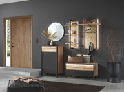 Moderner Eingangsbereich mit Garderobenmöbeln in Holzoptik, rundem Spiegel und dekorativen Elementen, seitliche Perspektive.