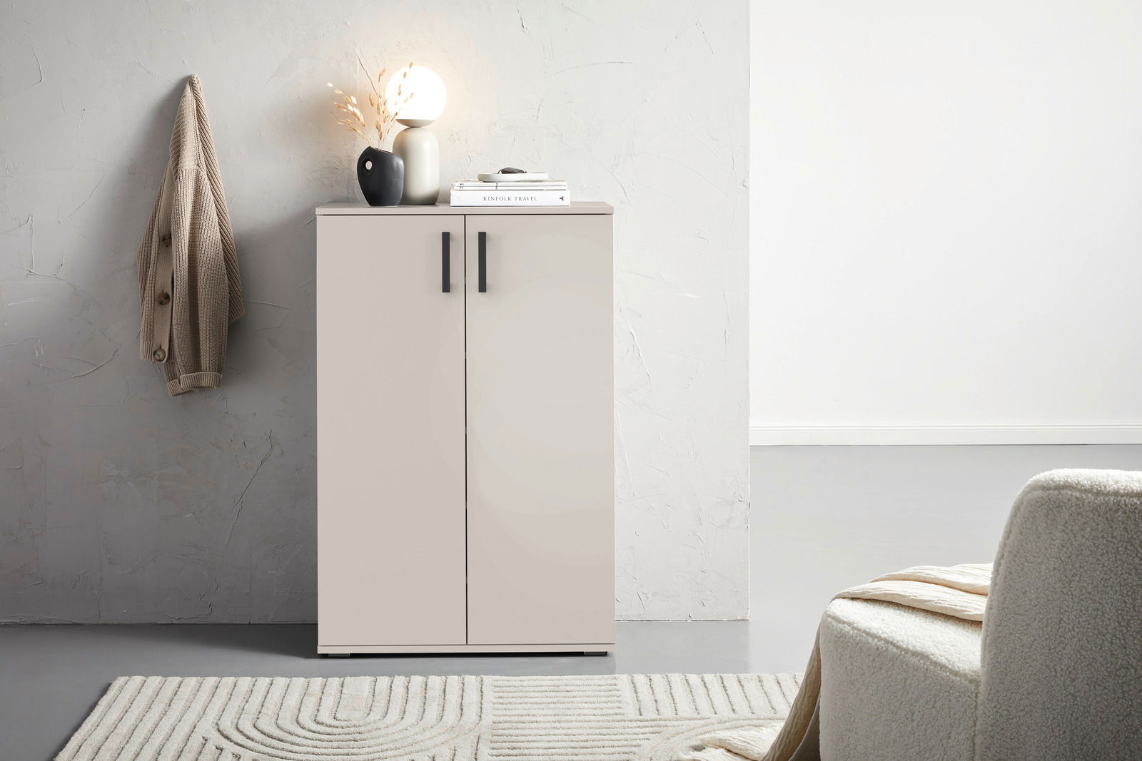 Moderner Schuhschrank in hellem Raum, frontal fotografiert, mit Dekoration auf der Oberseite.